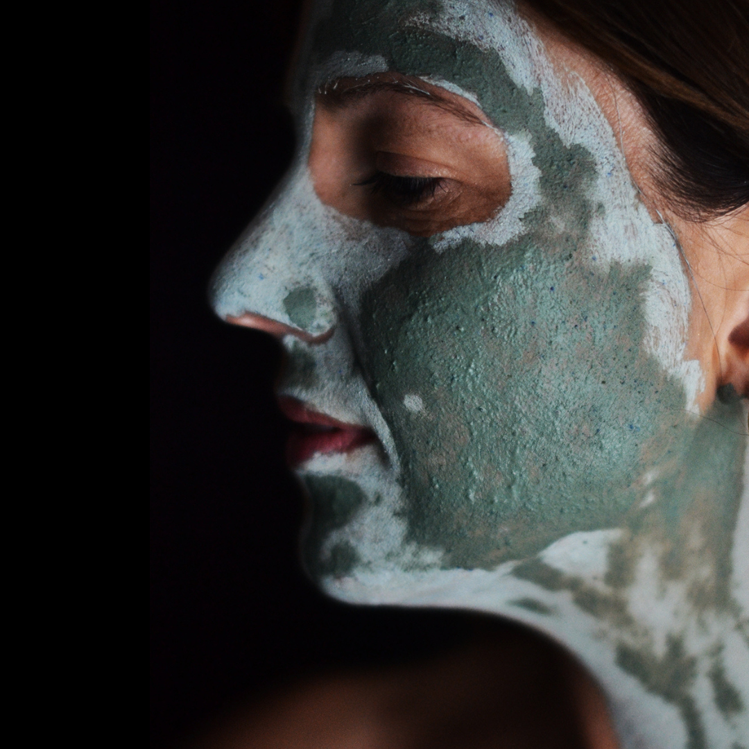 Side view of a person's face with the Oasis Black Mineral Clay Mud Mask in Byron - a stormy turquoise coloured mask featuring French Green Clay, Spirulina, Blue Butterfly Pea Flower, Lemon Myrtle and Black Seeds. Available exclusively from Oasis Black - makers of All Natural and Organic Botanical Skincare featuring Black Seeds (Nigella Sativa). All products are handmade in small batches to waterless formulations in the Byron Bay hinterland. 