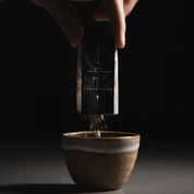 A sample size sachet of Oasis Black's Mineral Mud Mask in Nude, with the powder clay being poured out into a ceramic mixing cup. Nude is a pink coloured mask activated with water featuring French Pink Clay, Australian Clays, Aloe Vera, Chamomile, Rose petals and Black Seeds. Available exclusively from Oasis Black - makers of All Natural and Organic Botanical Skincare featuring Black Seeds (Nigella Sativa). All products are handmade in small batches to waterless formulations in the Byron Bay hinterland