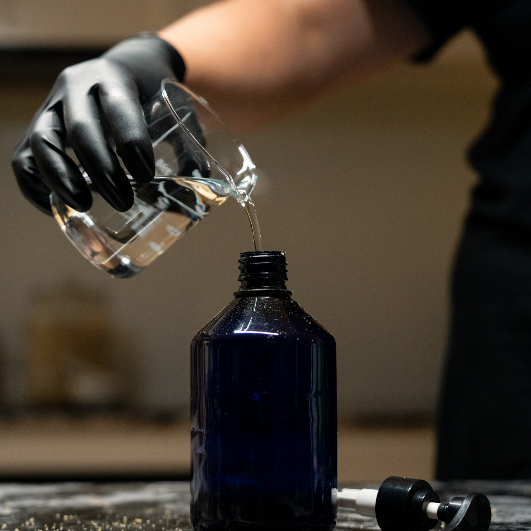 Person pouring 1 cup water into a blue bottle containing Oasis Black's Face & Body, Powder to Liquid Cleanser Concentrate in HEMP. Oasis Black's Cleanser Concentrates are All natural, zero waste castile soap based powdered cleansers that turn into liquid face and body wash with water. Available exclusively from Oasis Black - makers of All Natural and Organic Botanical Skincare featuring Black Seeds (Nigella Sativa). Handmade in small batches to waterless formulations in the Byron Bay Hinterland.