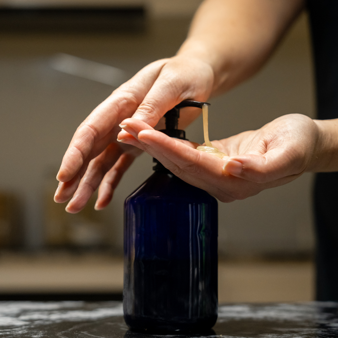 Person pumping Oasis Black's Face & Body, Powder to Liquid Cleanser Concentrate in HEMP, activated with water from a blue soap dispenser. Oasis Black's Cleanser Concentrates are All natural, zero waste castile soap based powdered cleansers that turn into liquid face and body wash with water. Available exclusively from Oasis Black - makers of All Natural and Organic Botanical Skincare featuring Black Seeds (Nigella Sativa). Handmade in small batches to waterless formulations in the Byron Bay Hinterland.